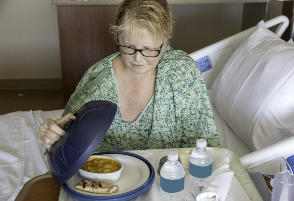 Hospital patient looks at her unappetizing hospital meal.