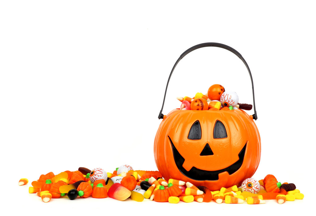 Halloween Jack o Lantern bucket filled with candy isolated on white